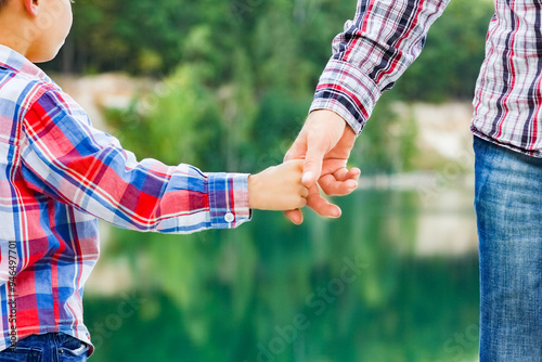 A Hands of parent and child in nature in the park travel