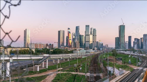 Time-Lapse of Moscow City Skyline Viewed Through Torn Fence at Sunset