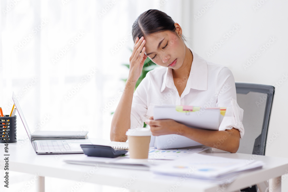 Portrait of tired young business Asian woman work with documents tax laptop computer in office. Sad, unhappy, Worried, Depression, or employee life stress concept. Portrait of tired young business Asian woman work with documents tax laptop computer in office. Sad, unhappy, Worried, Depression, or employee life stress concept.