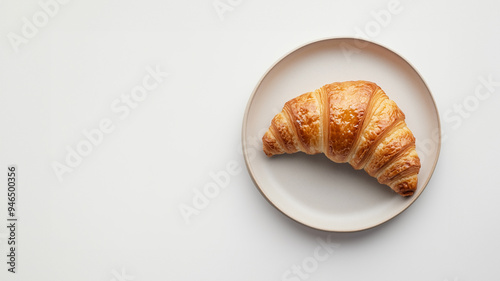 top view scene of a croissant on a plate above white background photo