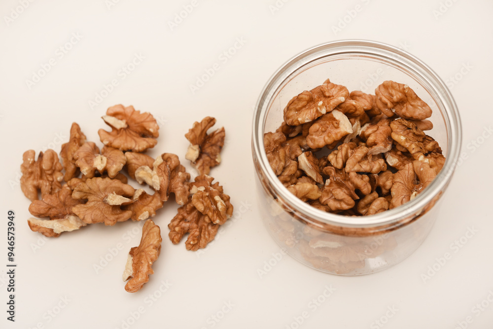 Walnuts in a plastic jar on a white background. Walnuts in a plastic jar on a white background.