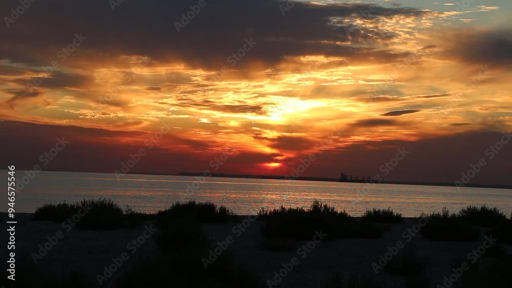 Dramatic evening red sky with the sun rays crossing the clouds. Harmony of seclusion and meditation near the beautiful sea waves. The golden or blue hour of the sunset. Kinburn, Ukraine Dramatic evening red sky with the sun rays crossing the clouds. Harmony of seclusion and meditation near the beautiful sea waves. The golden or blue hour of the sunset. Kinburn, Ukraine