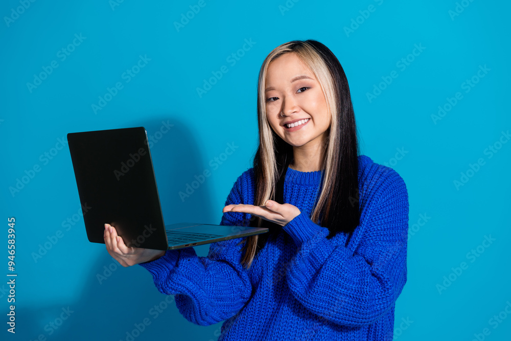 Photo of korean it specialist working remote young girl demonstrate her modern technology laptop isolated on blue color background Photo of korean it specialist working remote young girl demonstrate her modern technology laptop isolated on blue color background