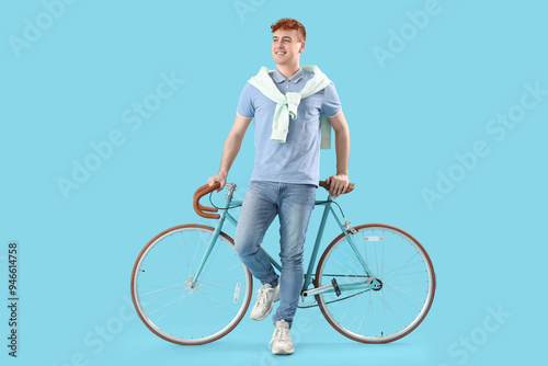 Young redhead man with bicy...