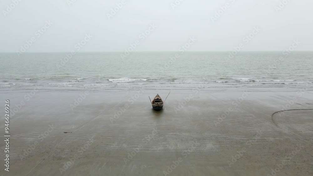 Aerial View of A single empty wooden fishing boat rest on a calm beach with a peaceful ocean backdrop. push forward shot Aerial View of A single empty wooden fishing boat rest on a calm beach with a peaceful ocean backdrop. push forward shot