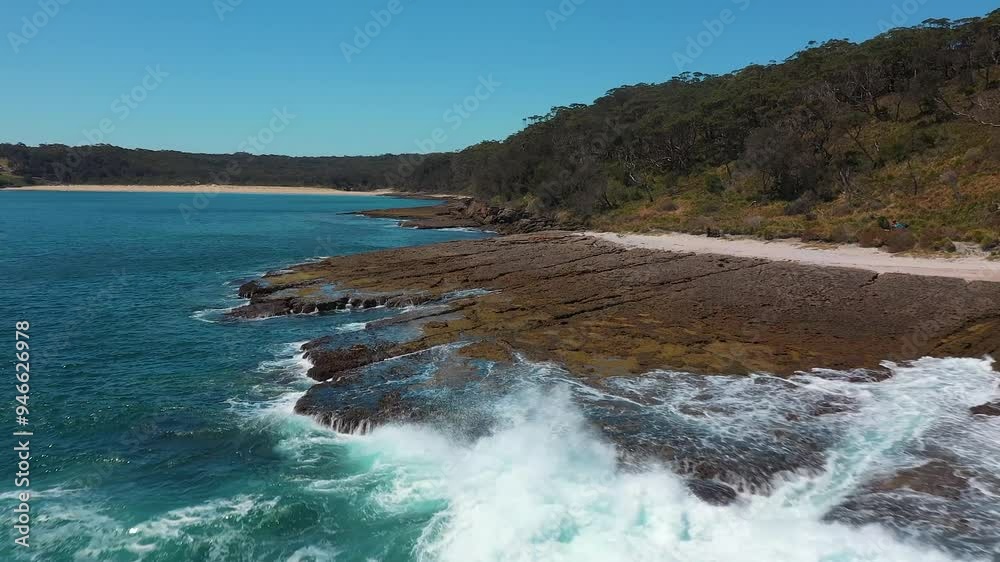 Aerial view of Australian rocky coastline, waves crashing on rock shelf and reef in Jervis Bay Aerial view of Australian rocky coastline, waves crashing on rock shelf and reef in Jervis Bay