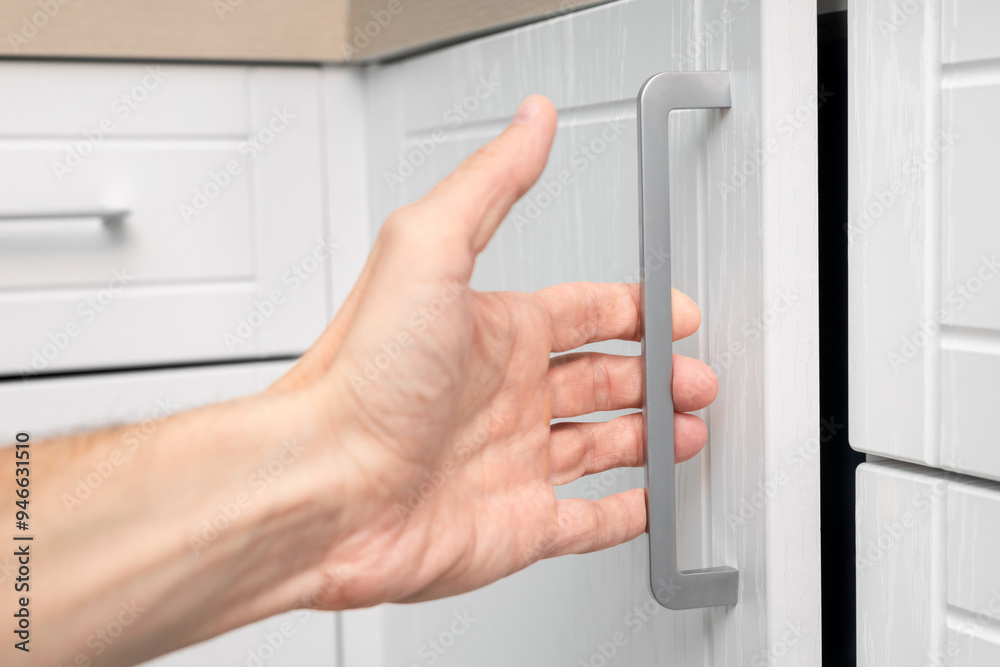a man's hand opens the kitchen cabinet door. man opens cabinet in kitchen. a man's hand opens the kitchen cabinet door. man opens cabinet in kitchen.