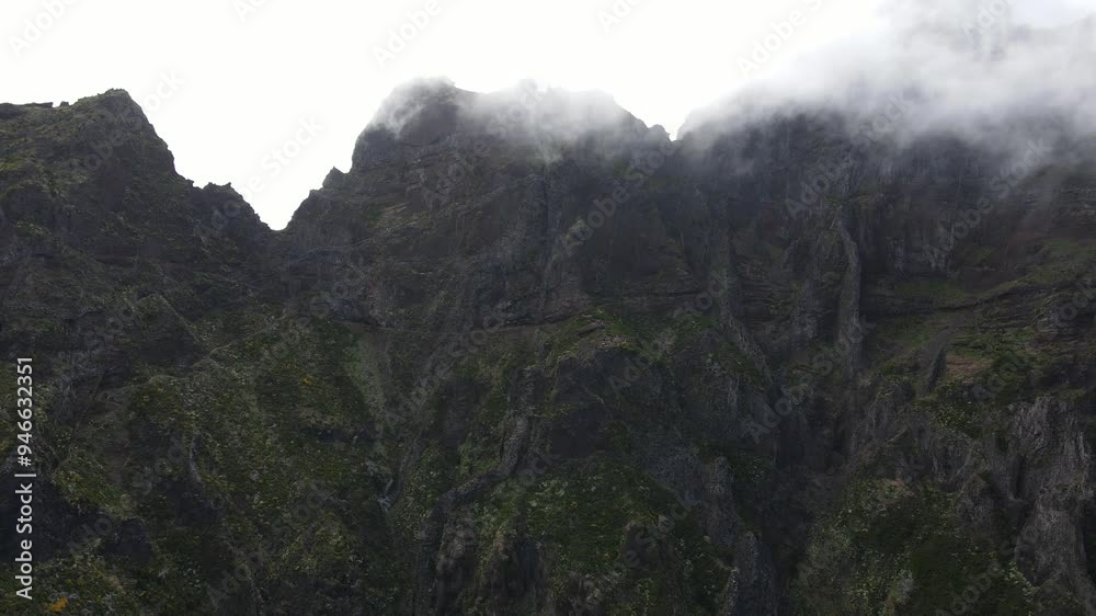 Aerial view of mountain peak above the clouds in serene rugged wilderness. Pico do Arieiro and Pico Ruivo, highest peaks in Madeira island, Portugal. Aerial view of mountain peak above the clouds in serene rugged wilderness. Pico do Arieiro and Pico Ruivo, highest peaks in Madeira island, Portugal.