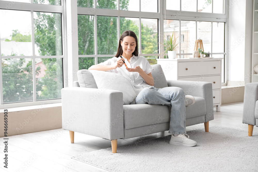 Diabetic young woman using lancet pen on sofa at home Diabetic young woman using lancet pen on sofa at home