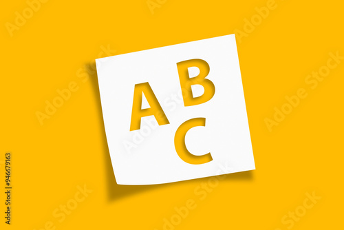 White note paper with Letters ABC on yellow background