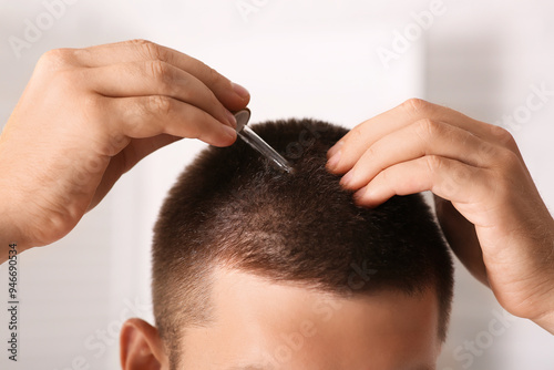Young man using serum for h...