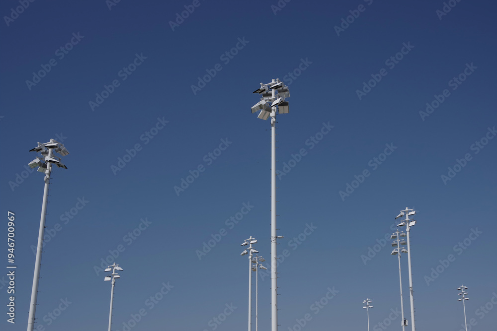 Tall sports stadium lighting masts and blue sky Tall sports stadium lighting masts and blue sky