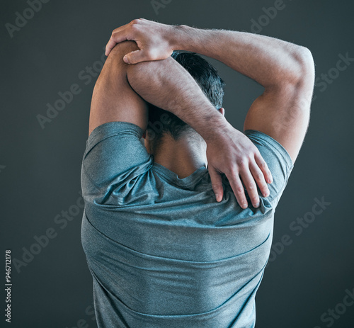 Stretching arms, fitness and back of man for exercise, training and warm up for workout on gray background. Health, sports and person with strength for wellness, performance and flexibility in gym