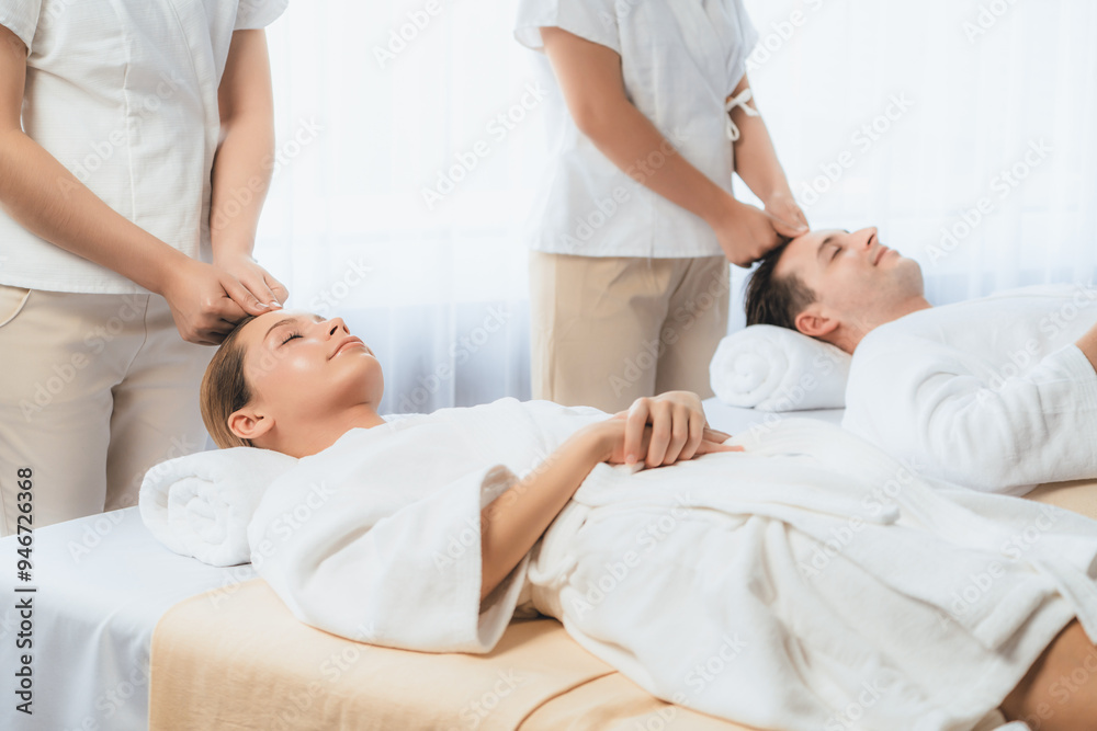Caucasian couple enjoying relaxing anti-stress head massage and pampering facial beauty skin recreation leisure in dayspa modern light ambient at luxury resort or hotel spa salon. Quiescent Caucasian couple enjoying relaxing anti-stress head massage and pampering facial beauty skin recreation leisure in dayspa modern light ambient at luxury resort or hotel spa salon. Quiescent