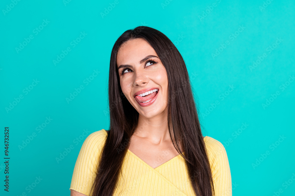 Fototapeta premium Photo of nice young woman look empty space lick teeth wear top isolated on teal color background