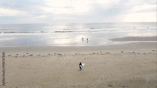 Surfers Walking on Beach photo