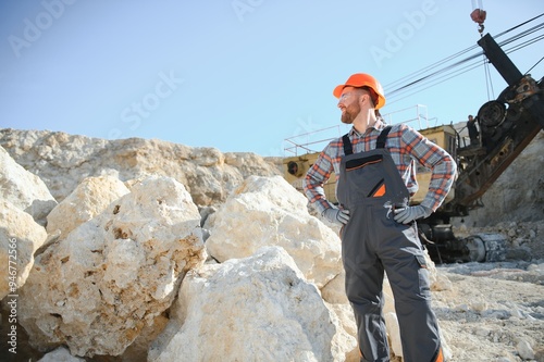 Portrait of a worker standing on the background of a stone quarry photo