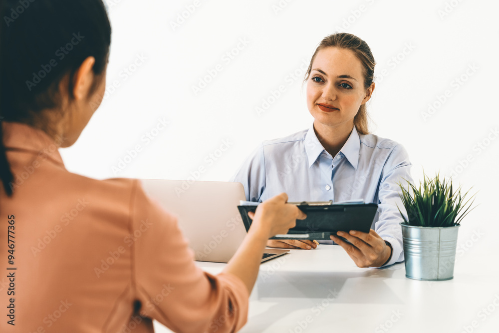 Two young business women in meeting at office table for job application and business agreement. Recruitment and human resources concept. uds Two young business women in meeting at office table for job application and business agreement. Recruitment and human resources concept. uds