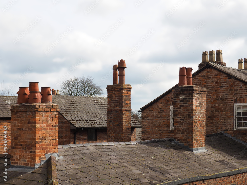 Φωτογραφία rooftop view of old british brick houses with slate roofs and tall chimneys in C