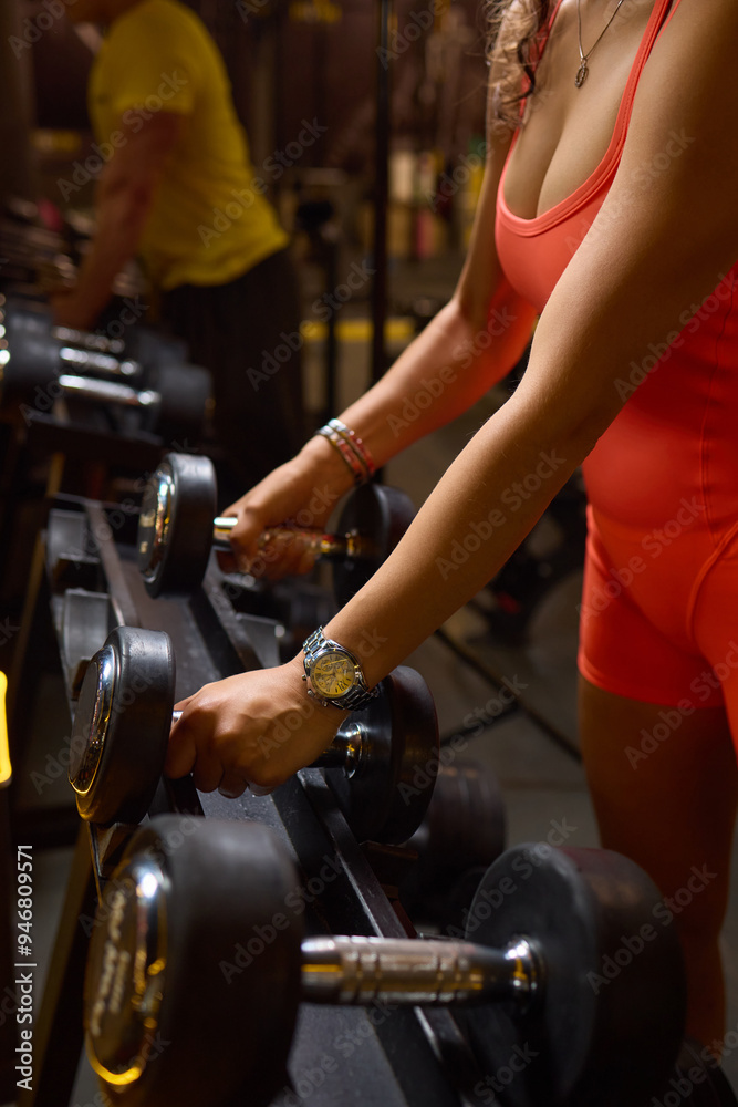Fototapeta premium Engaging in an Intense Workout Session Utilizing Dumbbells While Clad in Bright Gym Attire