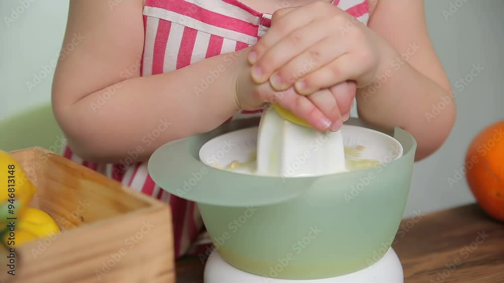 Little girl squeezing an orange on a juicer and smiles charmingly. High quality 4k footage Little girl squeezing an orange on a juicer and smiles charmingly. High quality 4k footage