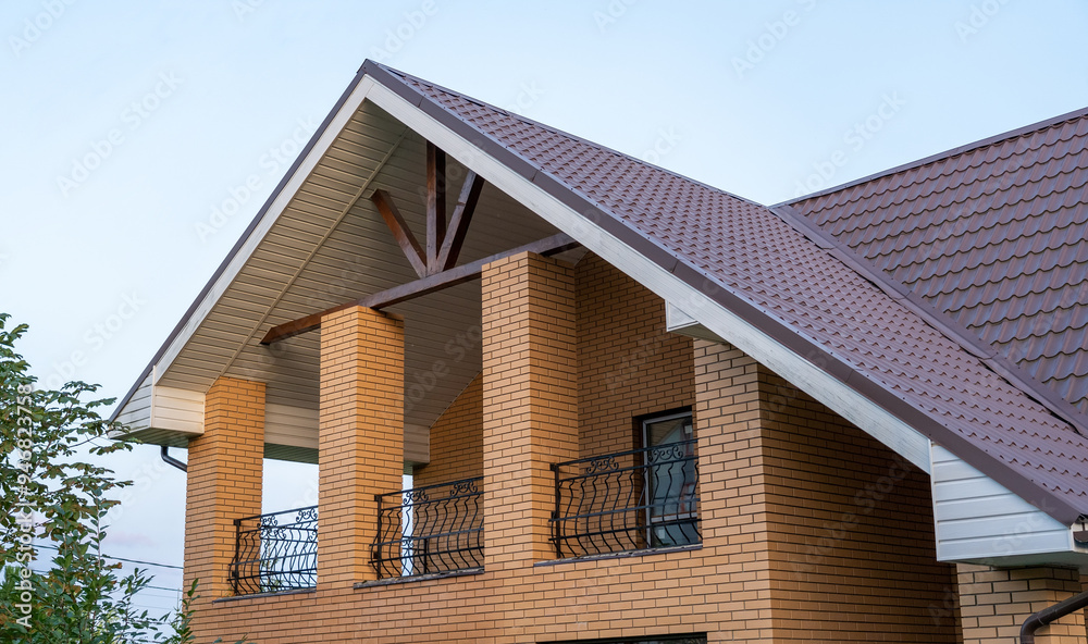 A contemporary house features a sloped roof and stylish balcony, blending classic and modern architectural elements under a clear sky A contemporary house features a sloped roof and stylish balcony, blending classic and modern architectural elements under a clear sky