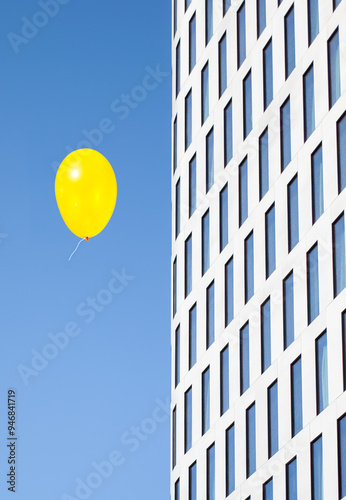 building in the city in contrast with a yellow kids balloon