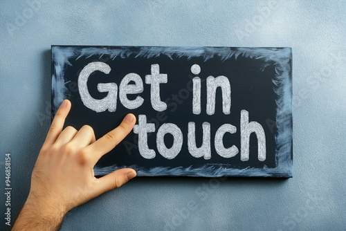 A hand is positioned near a chalkboard displaying the phrase get in touch, emphasizing communication and connection through visual representation photo