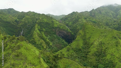 Aerial view of lush green mountains and serene valleys with a beautiful waterfall, Kauai, United States. photo