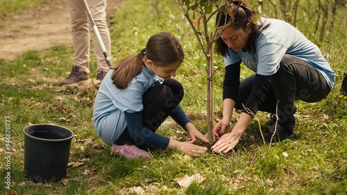Fotografi Diverse volunteers team planting trees seeds in the forest, digging holes to preserve natural habitat and cultivate life after