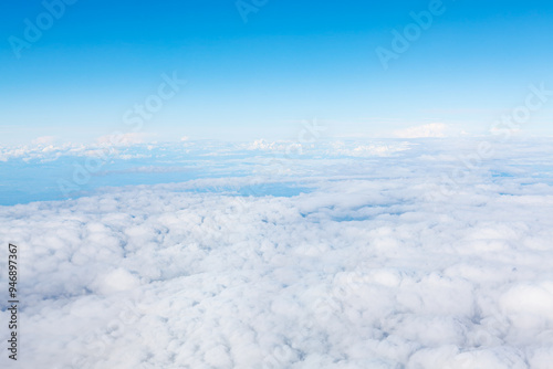 Blue sky and a tranquil surrounding white clouds. The clouds are white and fluffy. The sky is vast and open, giving a sense of freedom and space