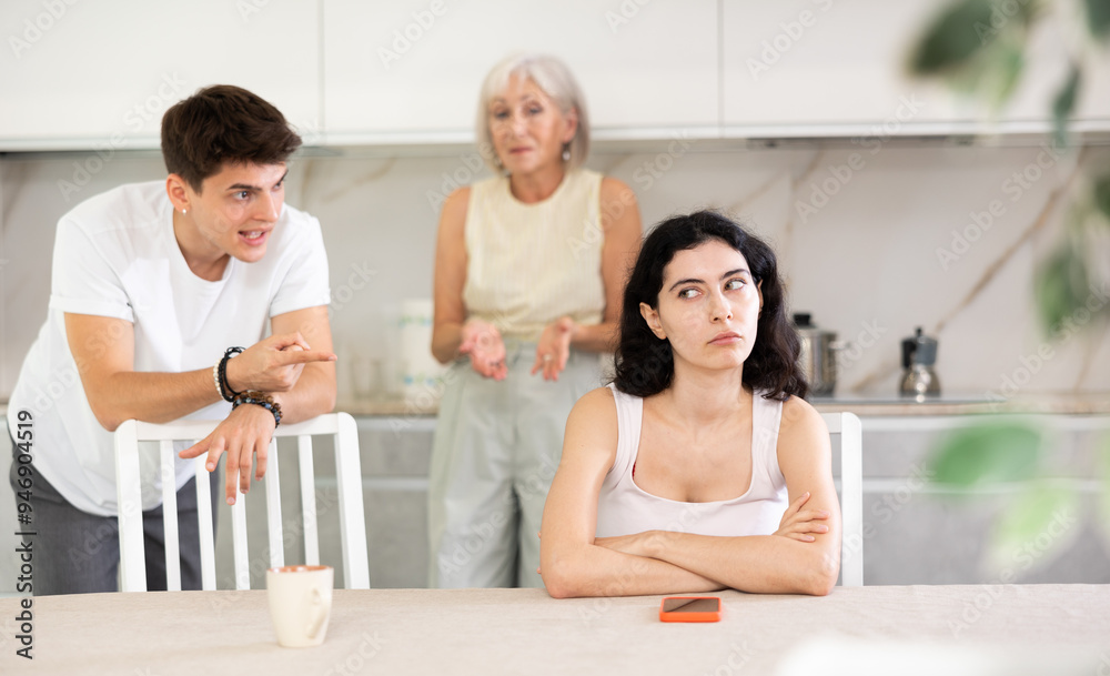 Fototapeta premium Upset woman dont speaking after discord with mother and husband standing behind