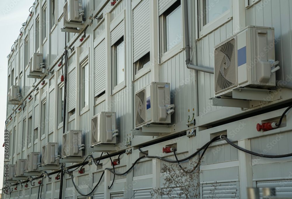 dużo klimatyzatorów zawieszonych na zewnętrznej elewacji budynku
