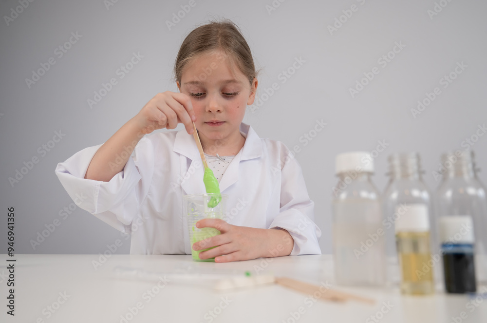 Caucasian girl doing chemical experiments on a white background. Making slime. Caucasian girl doing chemical experiments on a white background. Making slime.