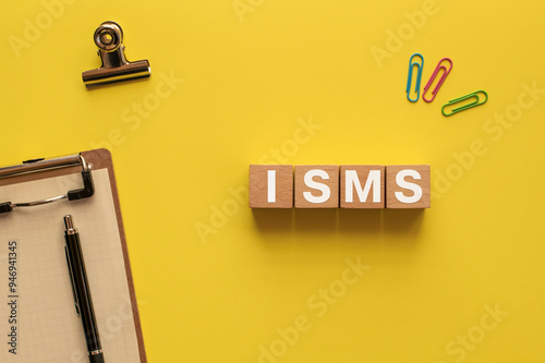 There is wood cube with the word ISMS. It is an abbreviation for Information Security Management System as eye-catching image. photo