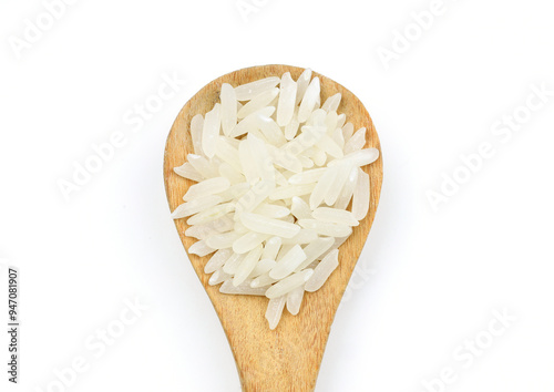 Raw white rice on wooden background. Long uncooked rice in wooden plate. Natural organic food. Traditional Asian cereal culture.