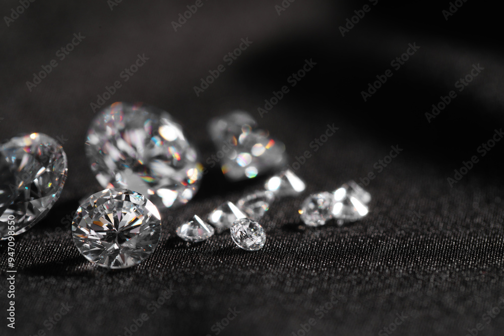 Many beautiful shiny diamonds on black fabric, closeup Many beautiful shiny diamonds on black fabric, closeup