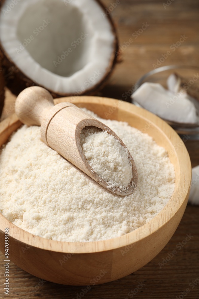 Coconut flour in bowl and scoop on wooden table, closeup Coconut flour in bowl and scoop on wooden table, closeup