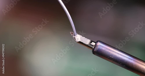 hot soldering iron and solder on the background of green boards, melting solder on a red-hot soldering iron