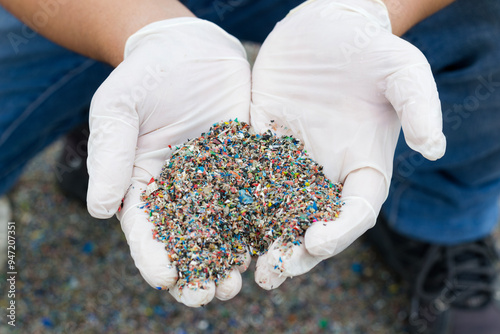 gloved hands gripping microplastic