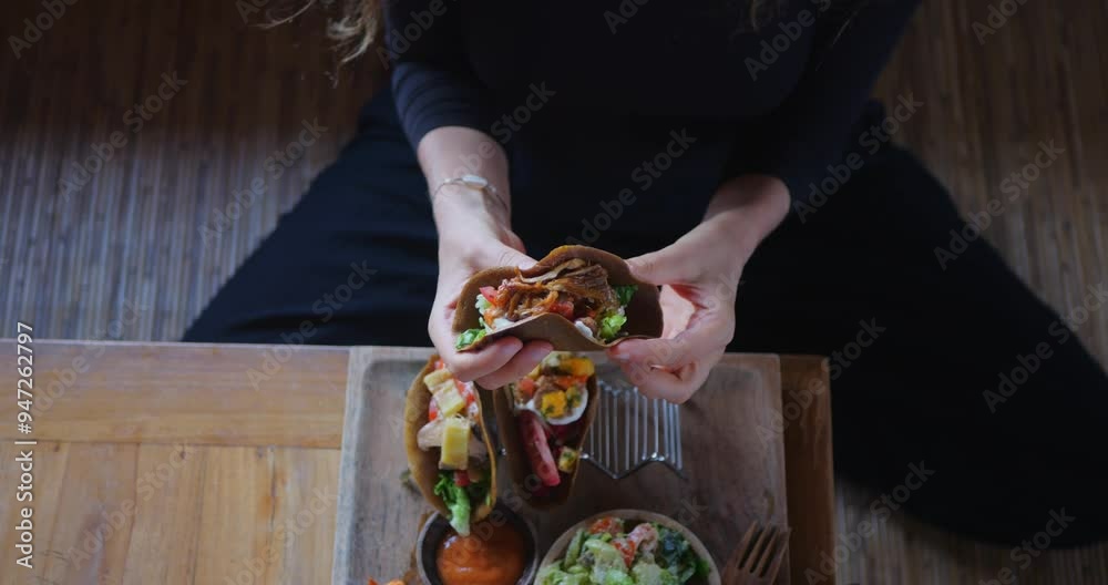 Top view of female hands holding taco in cozy cafe or restaurant. Healthy and delicious plate. 4K, slow-motion