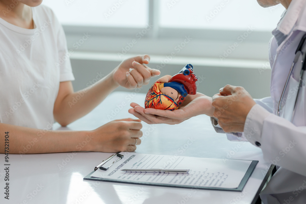 Fototapeta premium A doctor consults a patient on heart disease, explaining treatment options in a calm, professional setting.