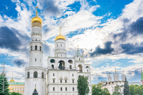 Ivan the Great Bell Tower, with Assumption Belfry on the right in Moscow Kremlin. Blue sky background with sunbeams