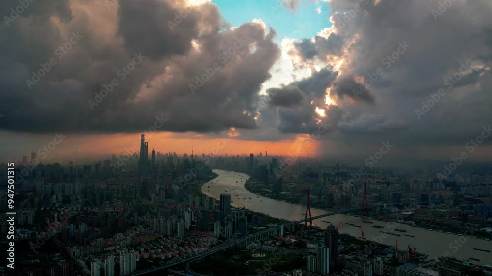 Drone view of Shanghai city in sunny cloudy rainy day at sunset, high angle view of ships sailing on Huangpu river and modern buildings with golden lights moving on sky, 4k time lapse footage.