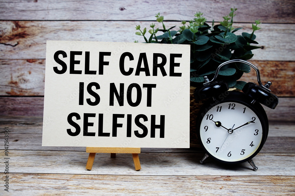 Self care is not selfish quotes text on paper card and easel standing with alarm clock on wooden background Self care is not selfish quotes text on paper card and easel standing with alarm clock on wooden background