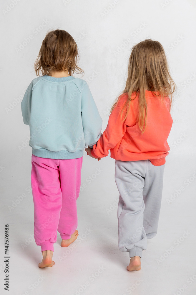 Two funny cute girls playing and having fun. Children with smiles and funny emotions on a light background. Vertical photo. High quality photo Two funny cute girls playing and having fun. Children with smiles and funny emotions on a light background. Vertical photo. High quality photo