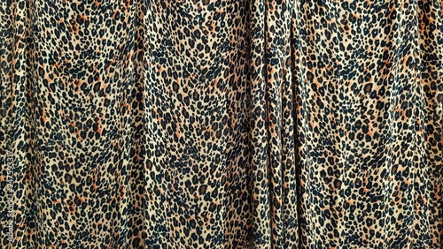 Close up of leopard print fabric curtain showcasing vibrant and intricate patterns. The image highlights the texture and wild feel of the animal inspired design. Perfect for fashion themed background.