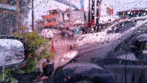 Raindrops on a car window with a blurred view of a bustling city street, conveying a sense of calm and reflection. Perfect for rainy day or mellow themed accompanied with sad and ballad songs.