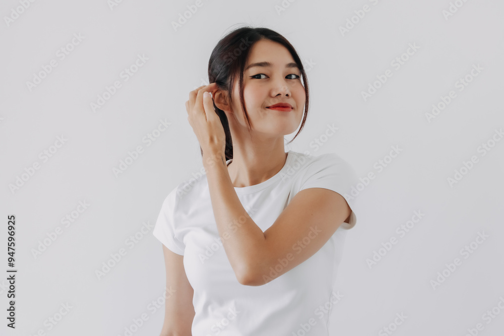 Asian Thai woman hand touching hair and ear, happy confident, smiling to camera standing isolated over white background wall. Asian Thai woman hand touching hair and ear, happy confident, smiling to camera standing isolated over white background wall.