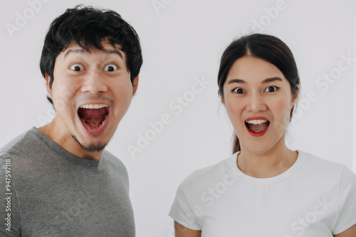 Funny wow and surprised face of asian Thai couples, both man and woman open wide mouth, standing isolated over white background wall.